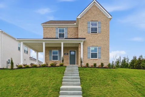 a front view of a house with a yard and garden