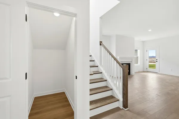 an empty room with wooden floor fireplace and windows