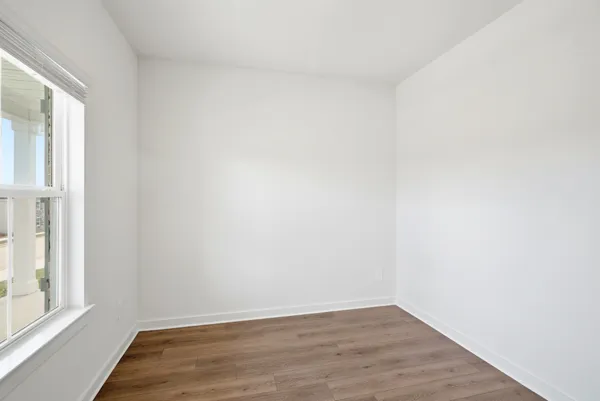 a view of a livingroom with wooden floor a fireplace and windows