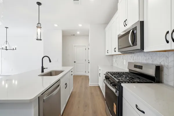 a kitchen with white cabinets and stainless steel appliances