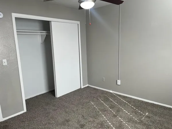 a view of an empty room with a chandelier fan