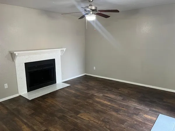 a view of empty room with wooden floor and fireplace