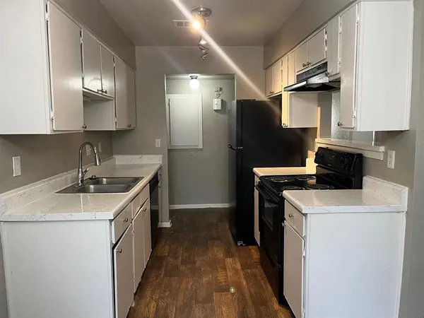 a kitchen that has a sink a stove and a refrigerator