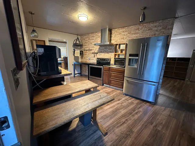 a kitchen with a refrigerator and wooden floor