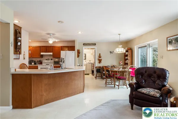 a kitchen with stainless steel appliances granite countertop a sink a stove a refrigerator cabinets and living room view