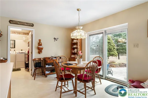 a kitchen with stainless steel appliances a dining table chairs and a refrigerator