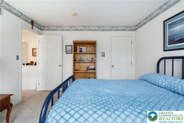 a bedroom with a bed large window with table and chair