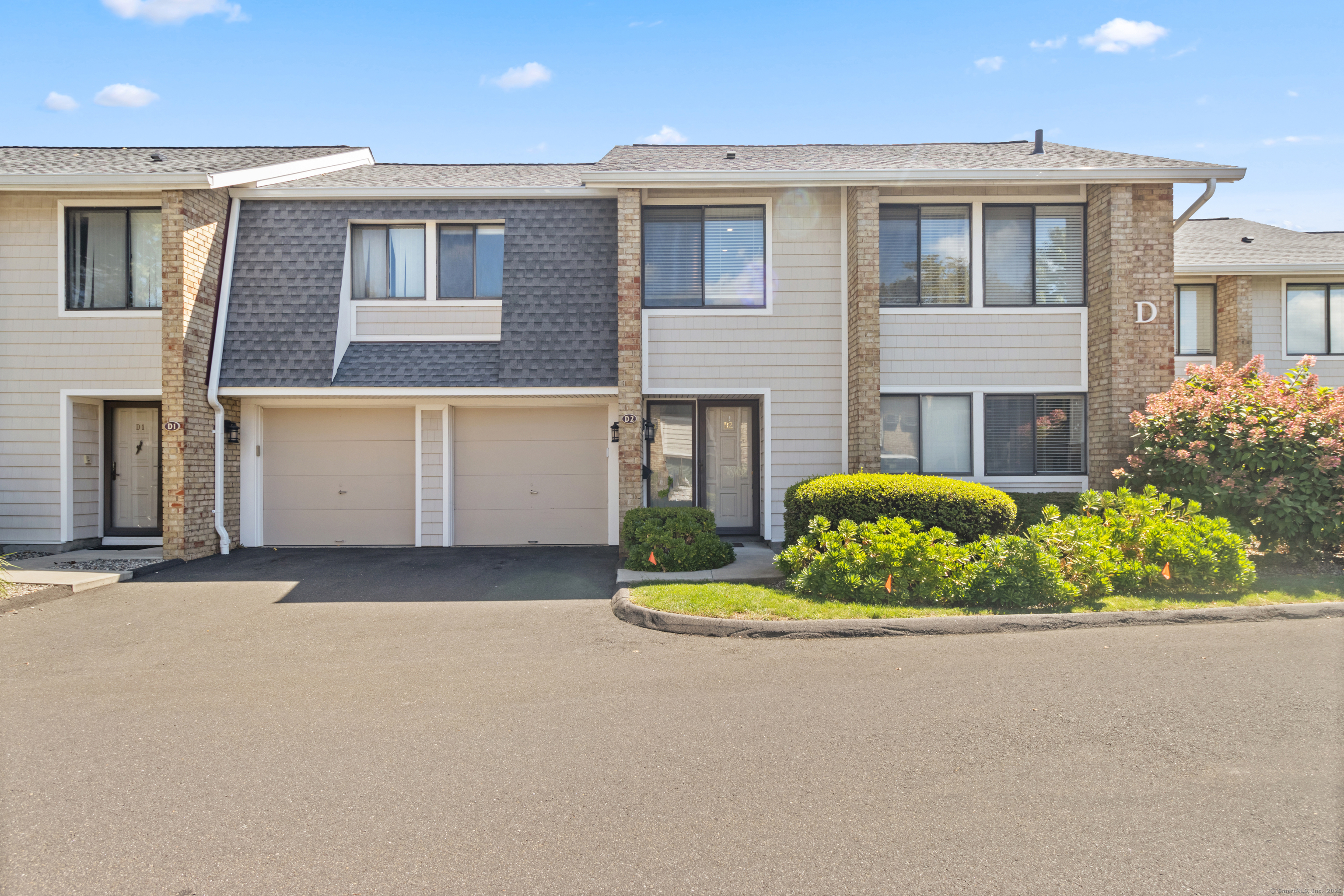 199 Gregory Boulevard, Unit D2 Norwalk, CT 06855 - Photo 4 of 31 a front view of a house with a yard and garage