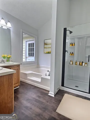 a bathroom with a tub sink and mirror