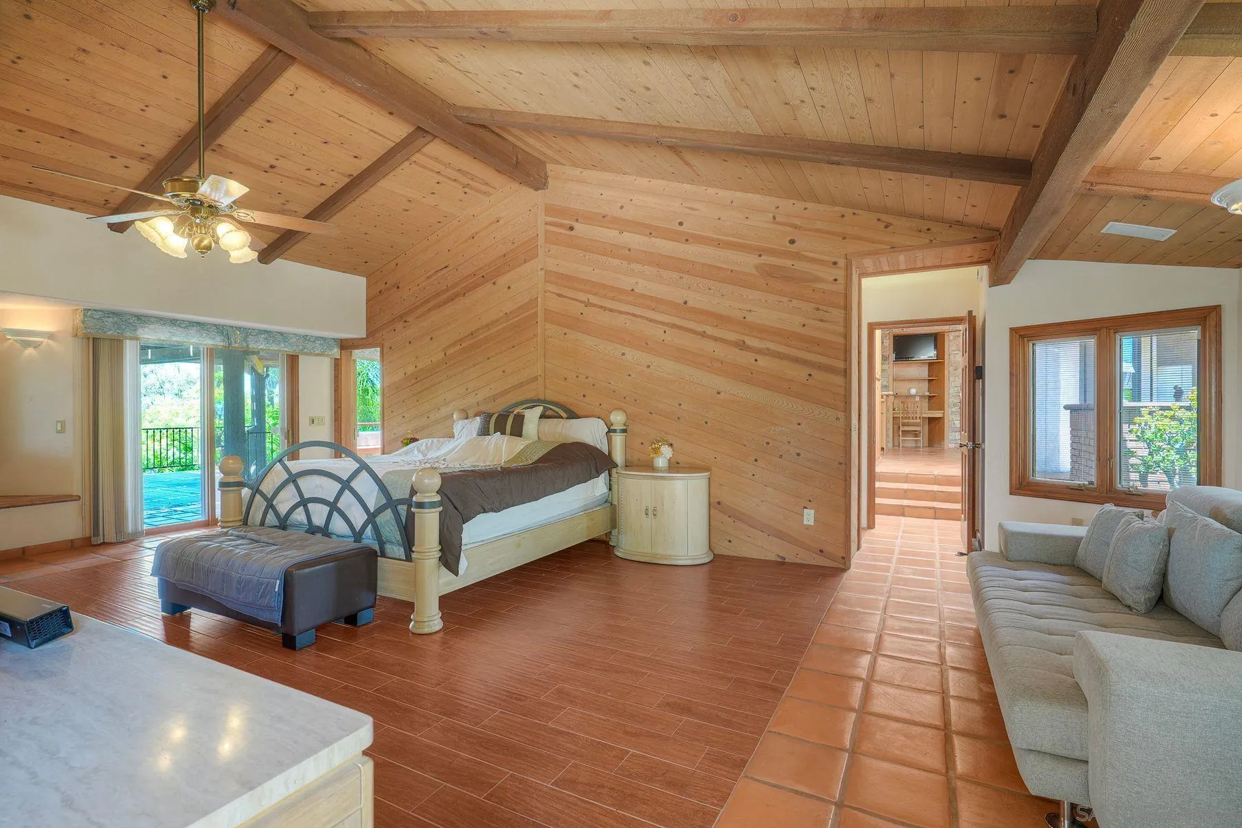 30458 Cool Valley Highlands Road Valley Center, CA 92082 - Photo 34 of 47 a spacious bedroom with a bed a couch and wooden floor