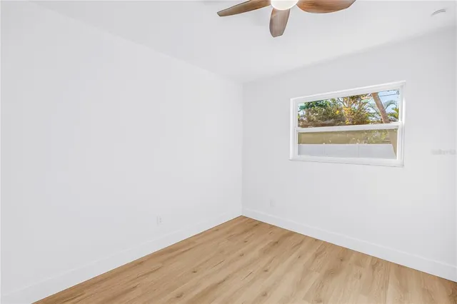 an empty room with a window and wooden floor