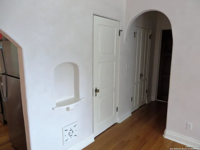 a view of a hallway with wooden floor