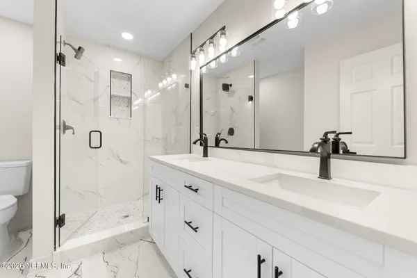 a bathroom with a shower sink vanity and mirror