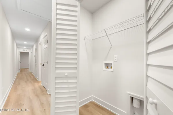 a view of a hallway with stairs and a window