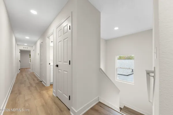 a view of a hallway with wooden floor and staircase