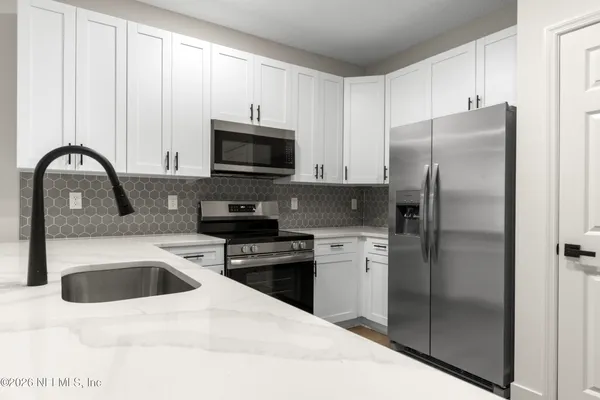 a kitchen with a refrigerator sink and stainless steel appliances