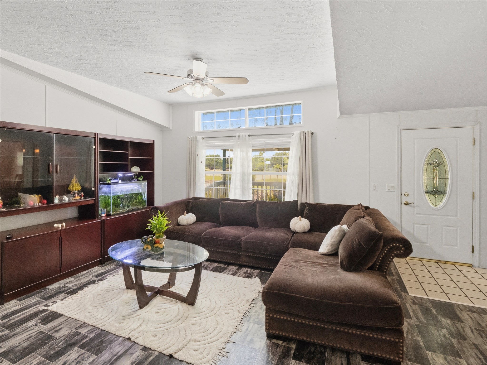 13241 2338th Road Georgetown, TX 78633 - Photo 7 of 26 A well-lit living area with dark wood-look flooring and a prominent built-in shelving unit awaits.
