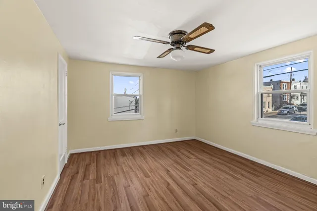 a view of a big room with wooden floor and windows