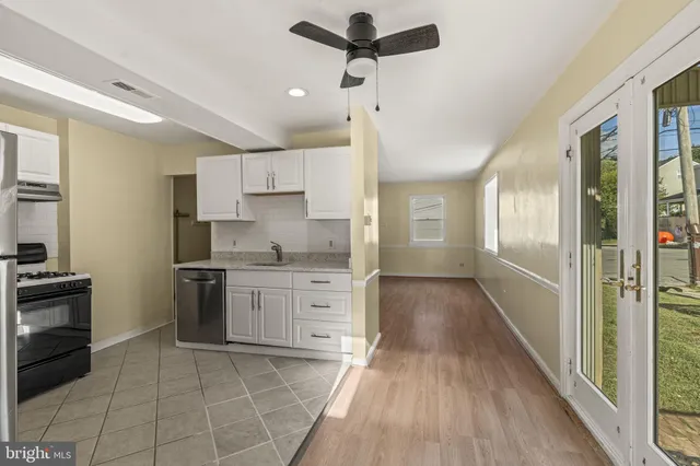 a kitchen with granite countertop a stove a sink and a refrigerator