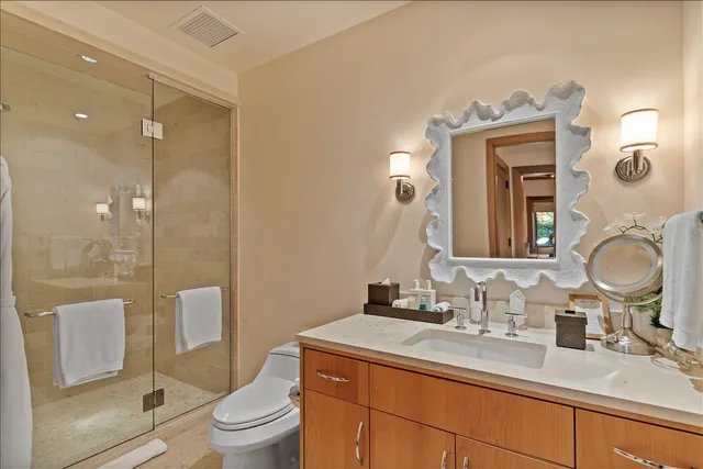 a bathroom with a granite countertop sink mirror toilet and shower