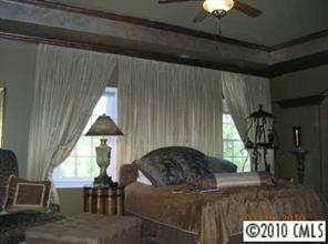 3421 Rhett Butler Place Charlotte, NC 28270 - Photo 7 of 8 a living room with a couch and a chandelier