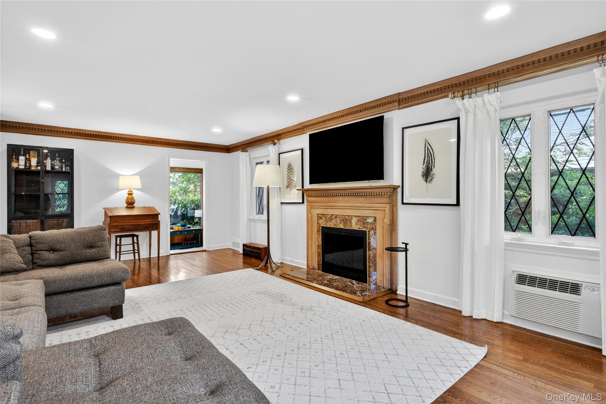 142 Mill Spring Road Manhasset, NY 11030 - Photo 6 of 23 a living room with furniture a fireplace and a flat screen tv