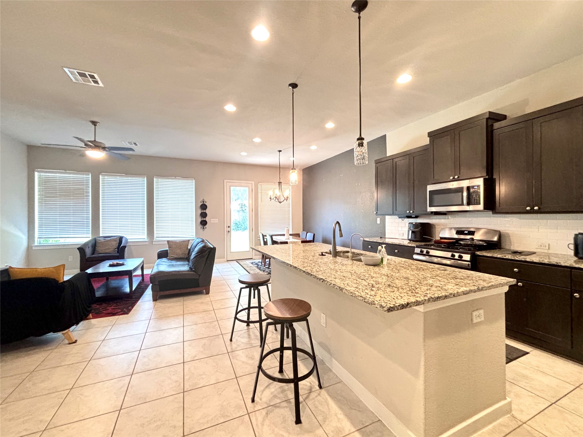 2017 Palmera Ridge Boulevard Leander, TX 78641 - Photo 2 of 6 An open-concept living space with a contemporary kitchen flows into a dining area, featuring ample natural light.