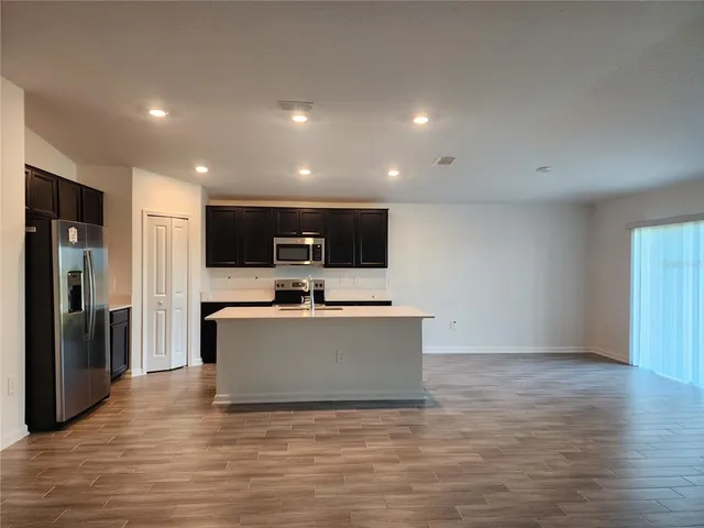 a view of kitchen with stainless steel appliances a refrigerator and a stove top oven