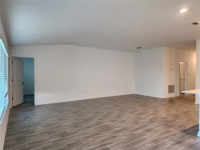 a view of an empty room and wooden floor