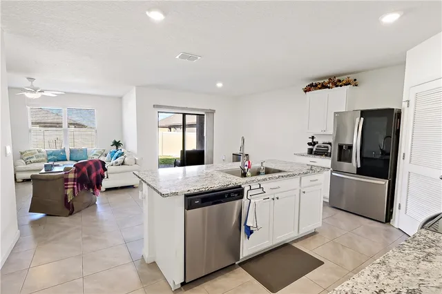 a kitchen with stainless steel appliances granite countertop a refrigerator sink and microwave