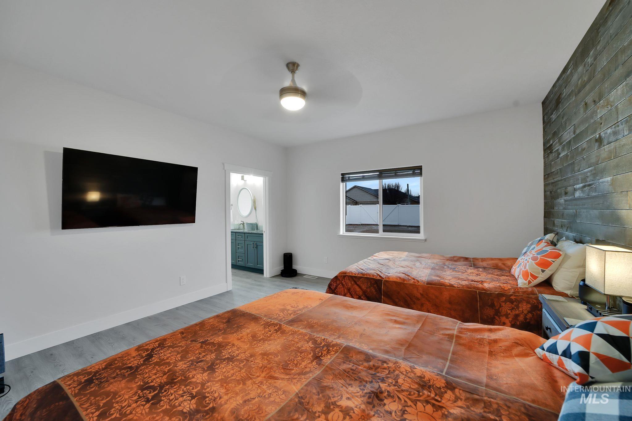 1085 Easy Avenue Twin Falls, ID 83301 - Photo 8 of 22 Bedroom with wood finished floors, a ceiling fan, and ensuite bathroom