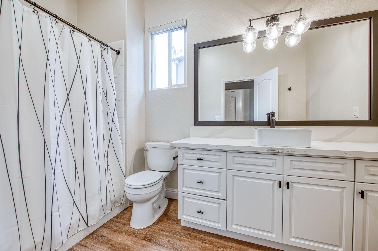 3252 Everglade Avenue Clovis, CA 93619 - Photo 18 of 31 a bathroom with a sink a toilet and a mirror