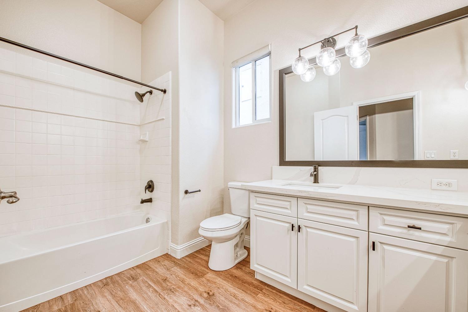 3252 Everglade Avenue Clovis, CA 93619 - Photo 24 of 31 a bathroom with a sink a toilet a large mirror and shower