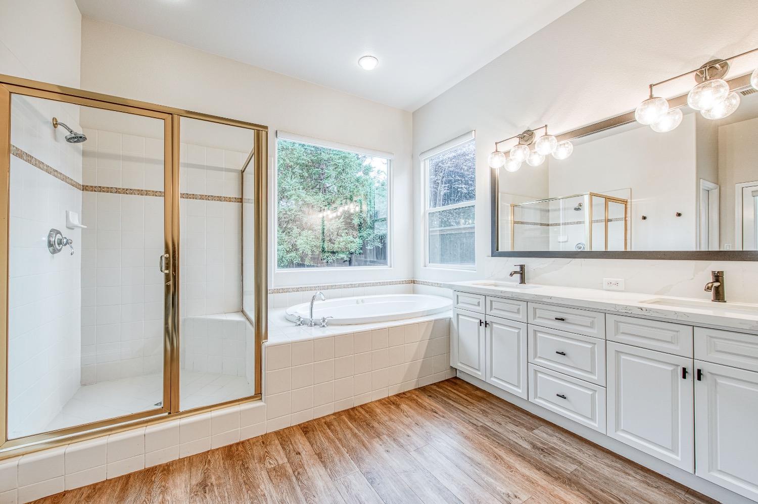 3252 Everglade Avenue Clovis, CA 93619 - Photo 28 of 31 a spacious bathroom with a double vanity sink a large mirror and shower