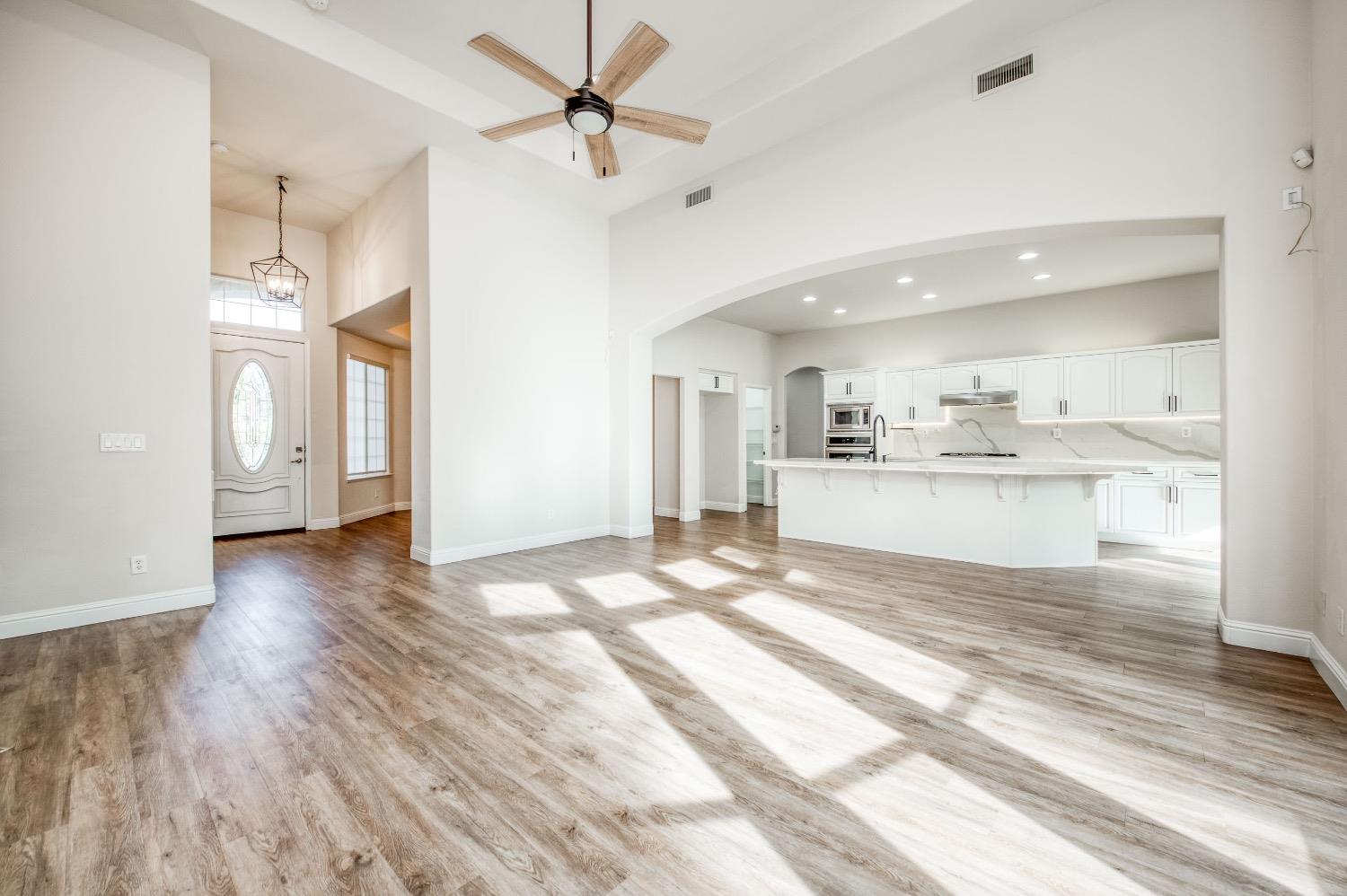 3252 Everglade Avenue Clovis, CA 93619 - Photo 5 of 31 a view of a kitchen and empty room with wooden floor
