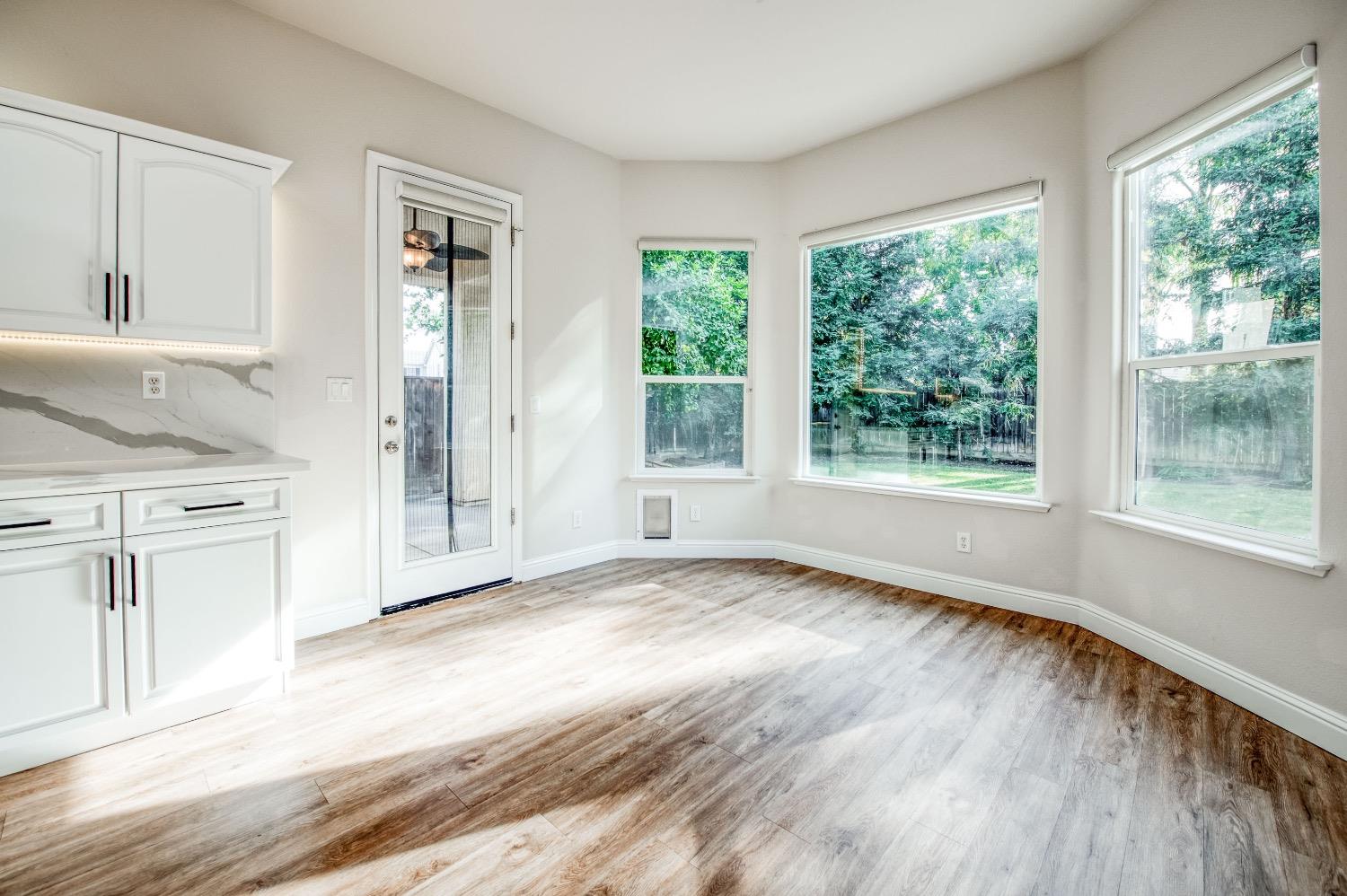3252 Everglade Avenue Clovis, CA 93619 - Photo 9 of 31 a view of a kitchen with wooden floor and natural light