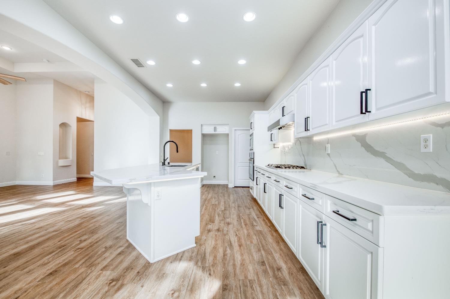 3252 Everglade Avenue Clovis, CA 93619 - Photo 10 of 31 a large kitchen with stainless steel appliances granite countertop a lot of counter space and wooden floor