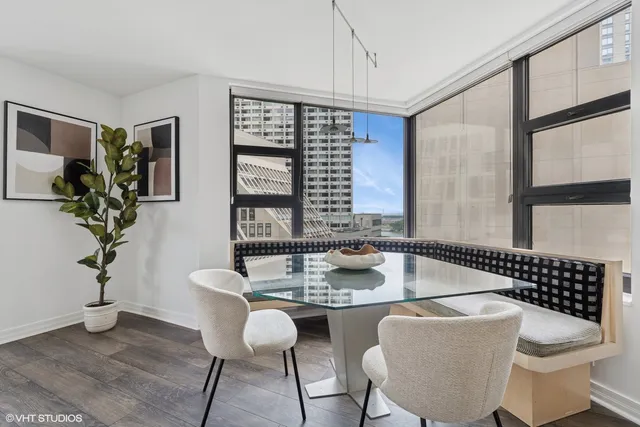 a dining room with furniture potted plants and wooden floor