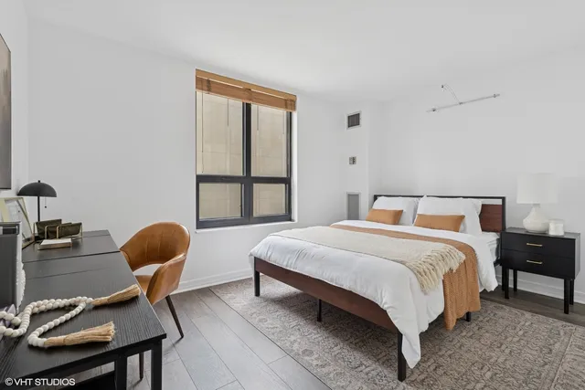 a bedroom with a bed chair and a window