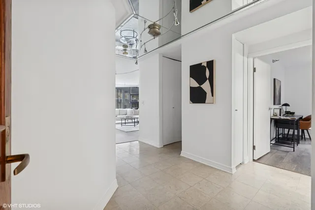 a view of a hallway with chandelier and entryway