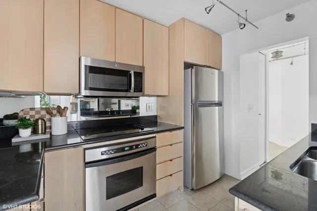 a kitchen with granite countertop a refrigerator stove and microwave