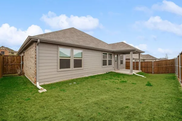 a yellow house sitting in middle of the grass