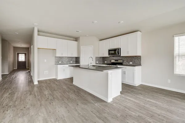 a kitchen with granite countertop a refrigerator stove top oven and sink