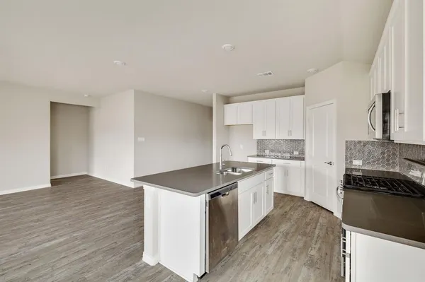 a kitchen with a stove top oven sink and cabinets