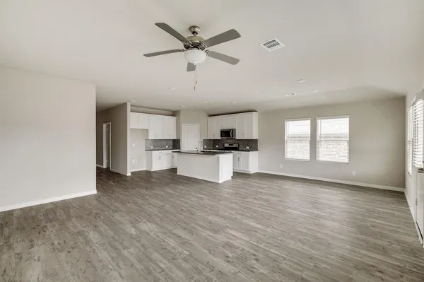 a view of a kitchen with wooden floor and windows