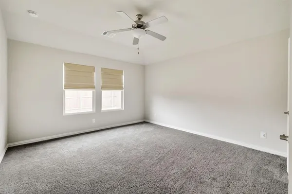 an empty room with a window and a ceiling fan