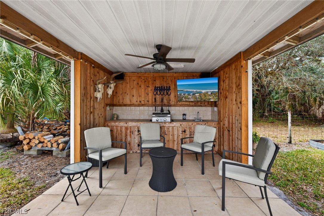 3790 Goggin Road Alva, FL 33920 - Photo 19 of 38 a view of a patio with table and chairs potted plants with floor to ceiling window