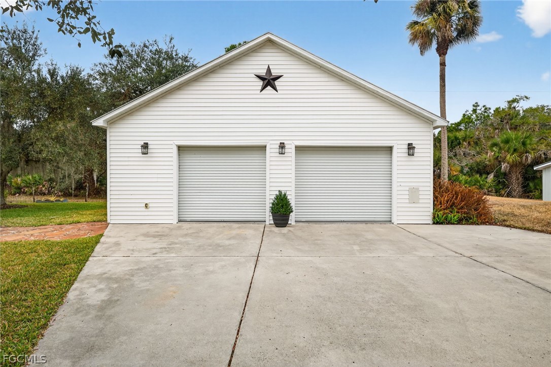 3790 Goggin Road Alva, FL 33920 - Photo 20 of 38 a view of a house with a backyard and garage