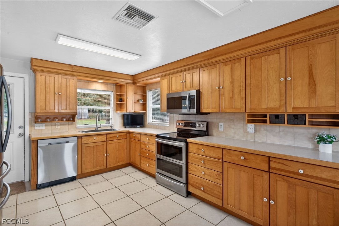 3790 Goggin Road Alva, FL 33920 - Photo 9 of 38 a kitchen with stainless steel appliances granite countertop a stove a sink dishwasher and a refrigerator