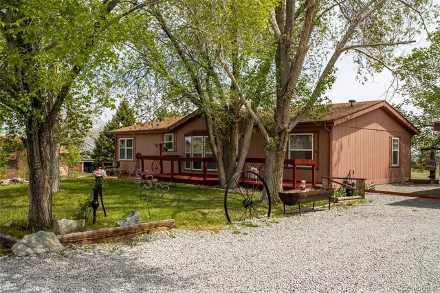 a view of a house with backyard and a tree